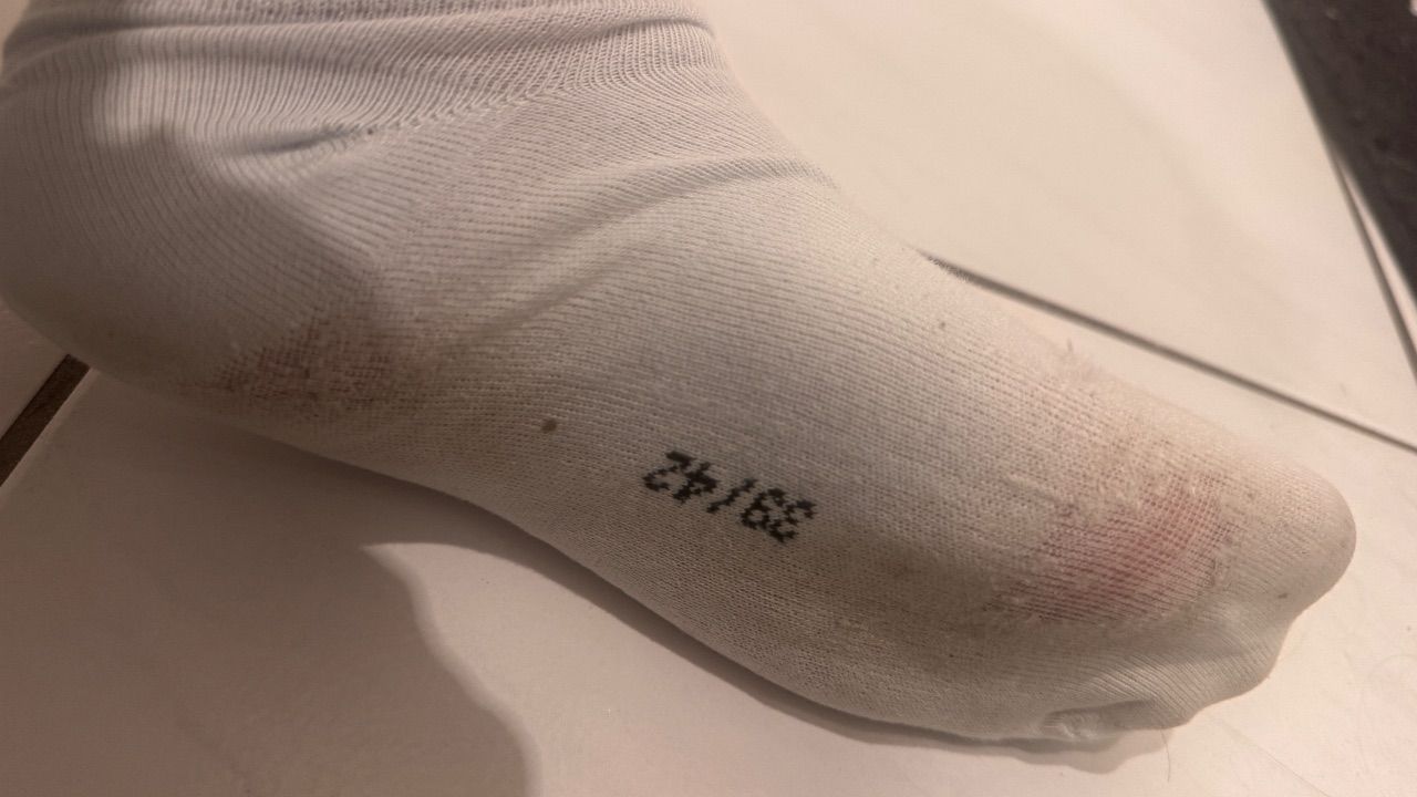 Getragene weiße Socken mit Löchern Size M