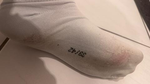 Getragene weiße Socken mit Löchern Size M