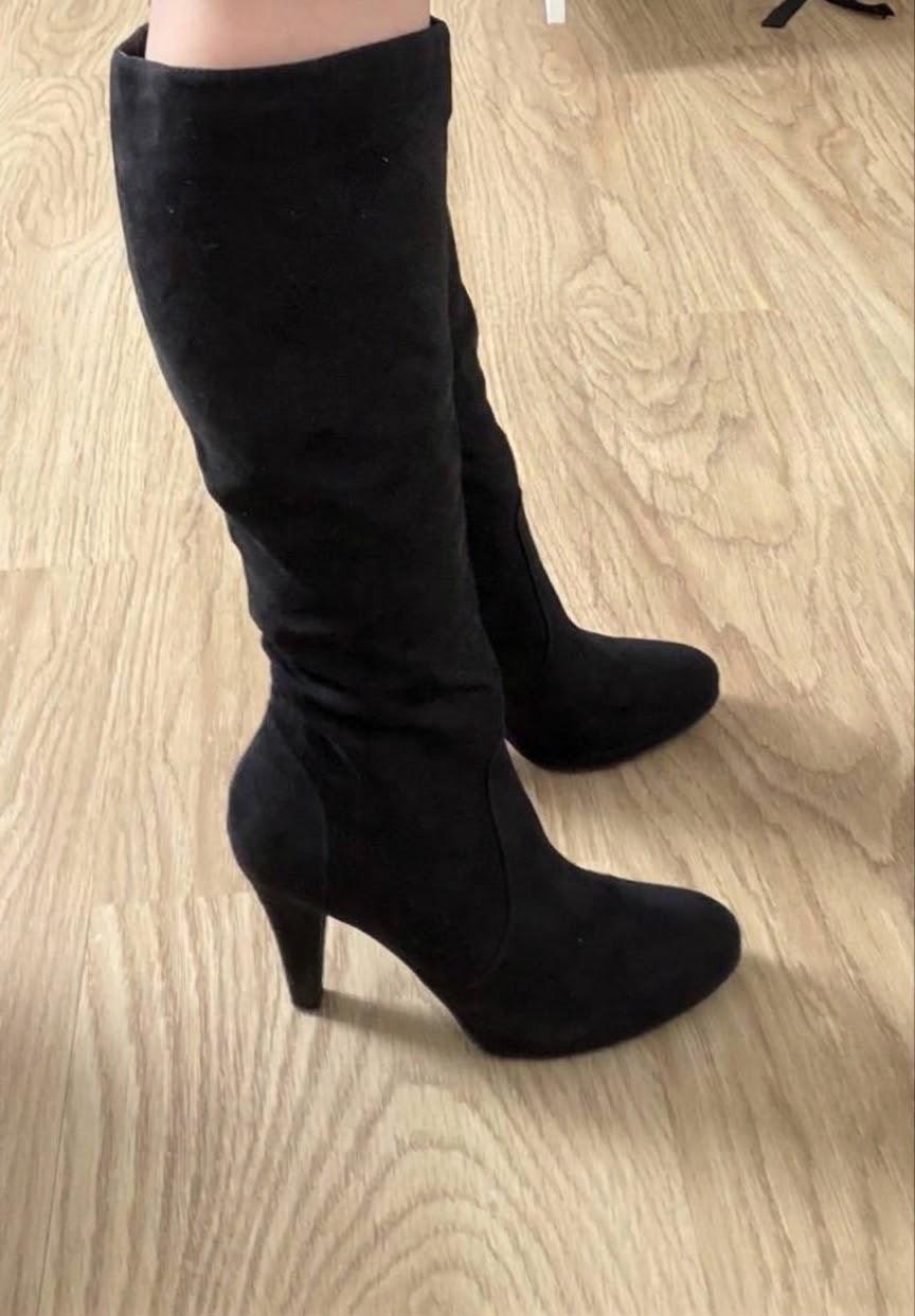Getragene, elegante schwarze Stiefel mit Absatz
